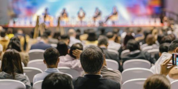 rear-view-of-audience-listening-speakers-on-the-stage-in-the-conference-hall-or-seminar-meeting-768x512 (1)